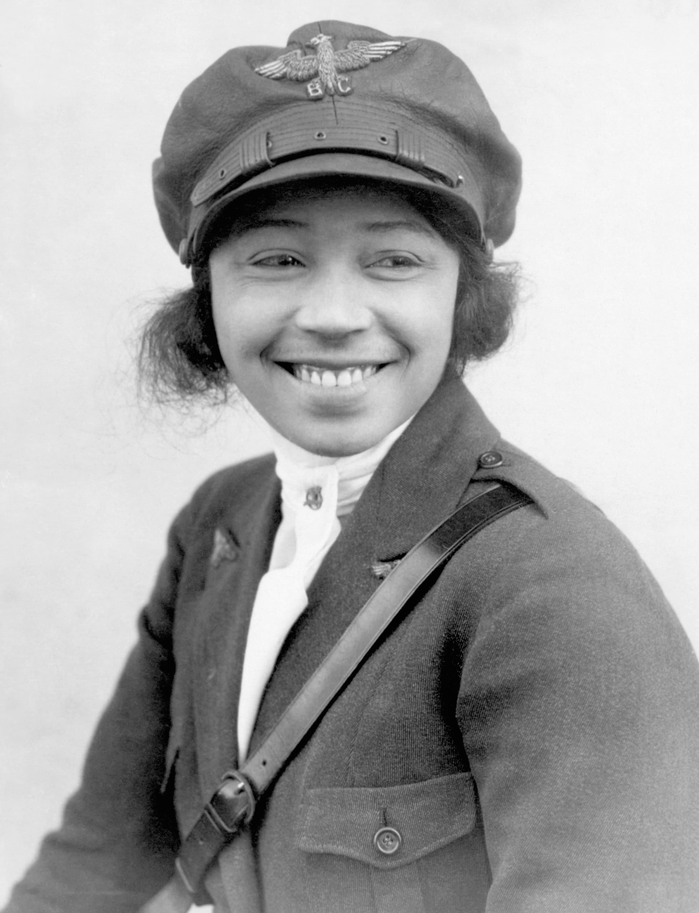 Bessie Coleman in flight gear standing beside her biplane, 1923.